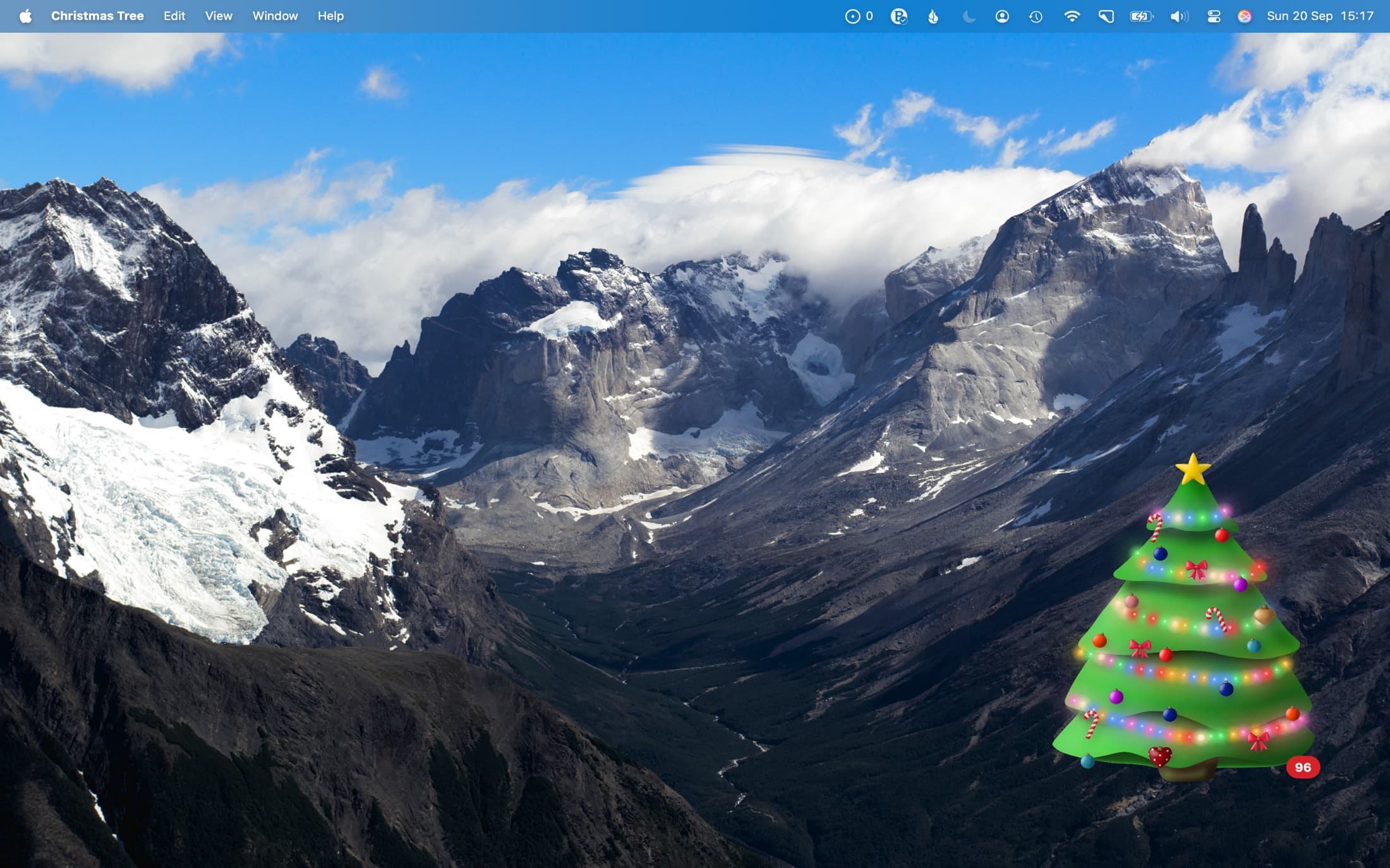 A Mac desktop with the decorated tree floating in the bottom right corner
